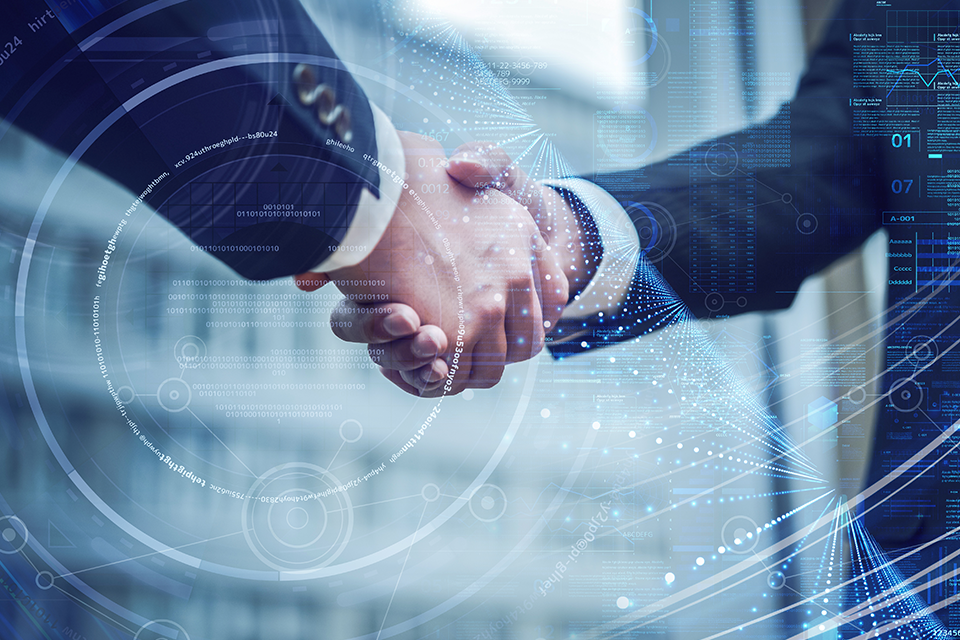 Two professionals shake hands amid a blue digital overlay with holographic data, symbolizing a tech partnership or collaboration.