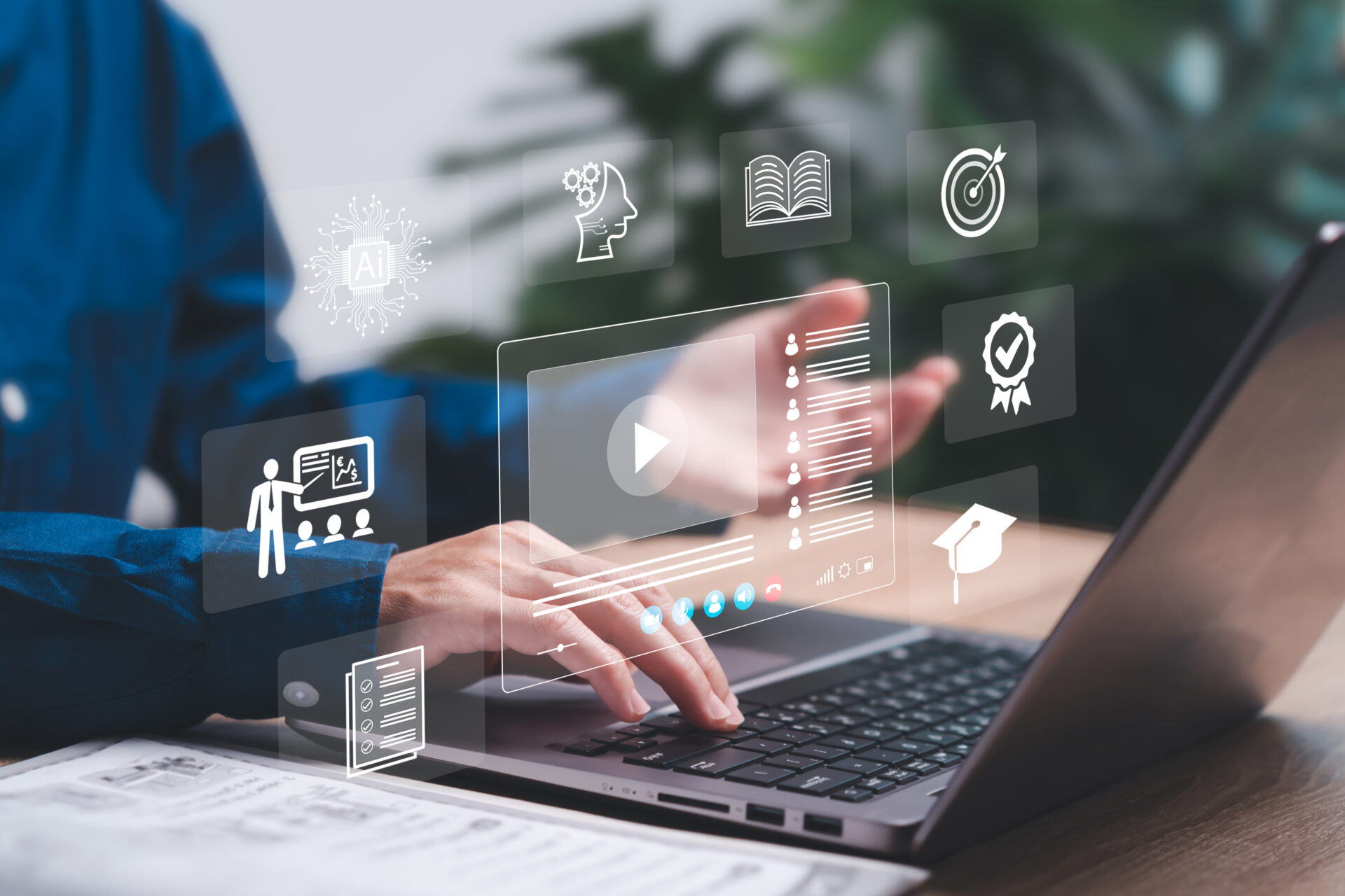 Education learning and technology Artificial intelligence for modern learning concept Young women use laptop learning with online application Communication and knowledge exchange through video | 日本最初の品質マネジメントシステム認証機関 -日本化学キューエイ株式会社 Hands typing on a laptop with translucent holographic icons for AI, learning, goals, and certificates.